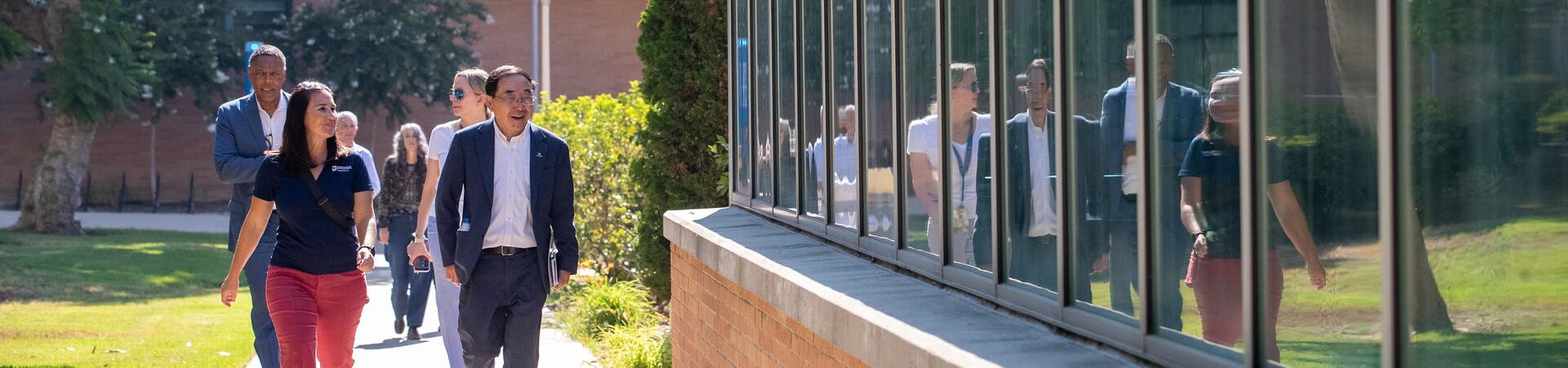 Lisa Laws, Associate Director of Housing, left, leads Chancellor S. Jack Hu, and other administrators and staff on a tour of the housing areas